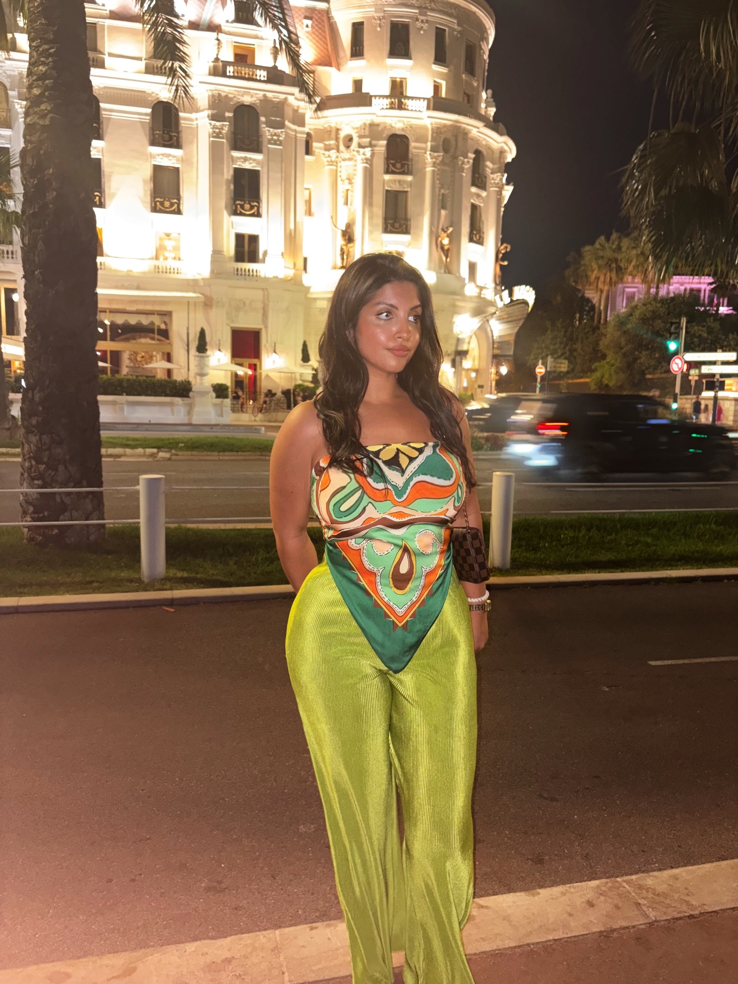 Kenza devant un palace illuminé la nuit